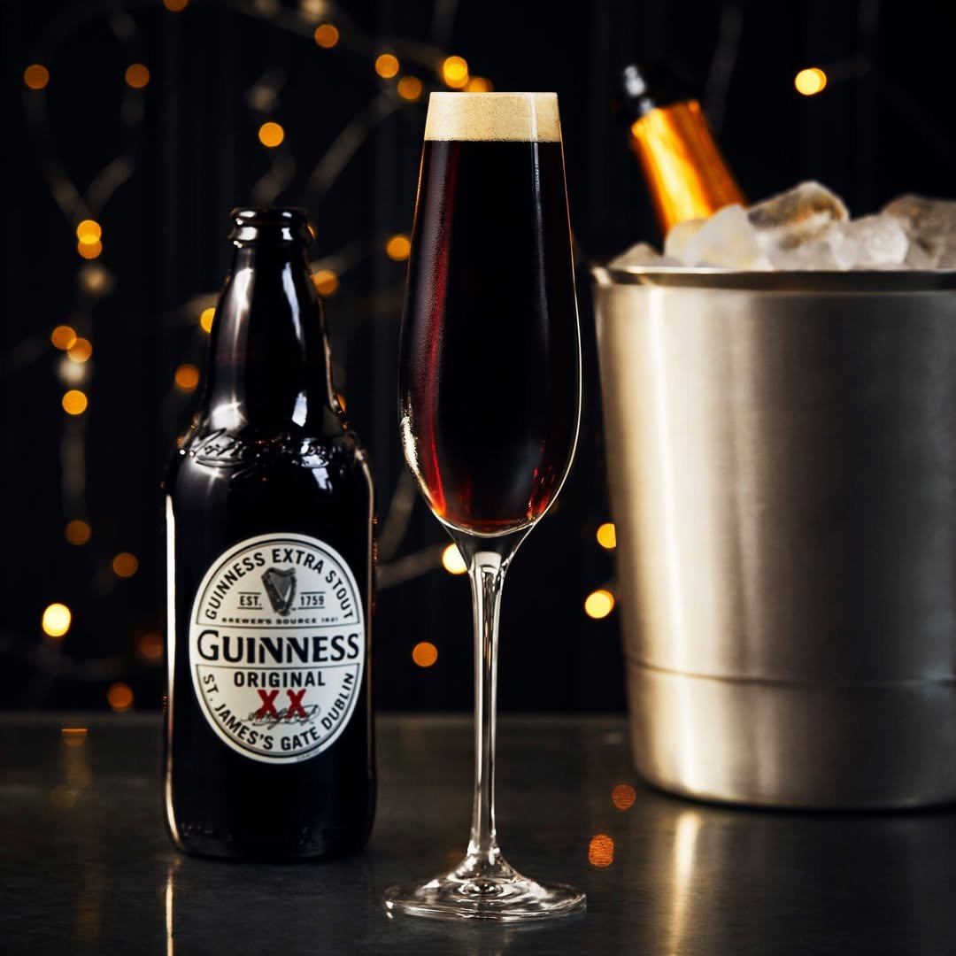 The black velvet beer cocktail beside a bottle of Guinness.