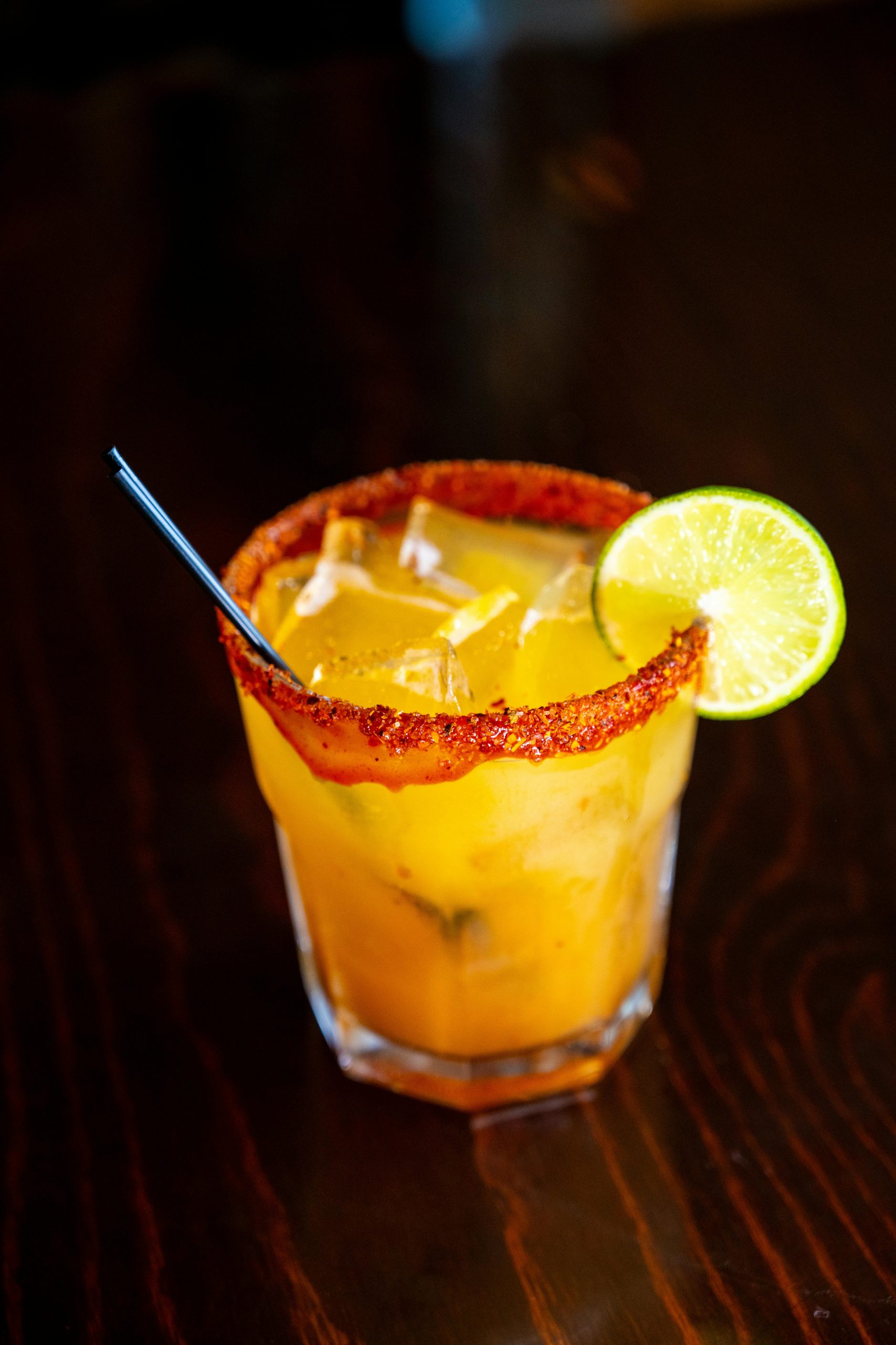 A mango chamoy beer cocktail on a wooden table